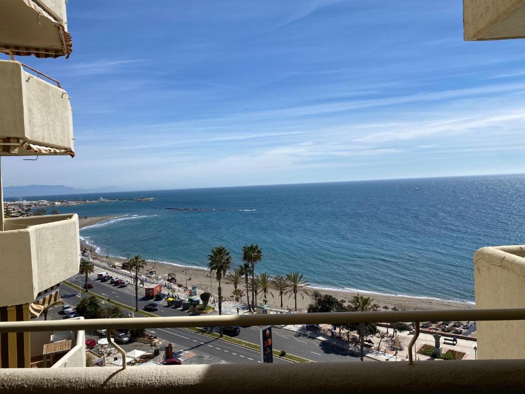 a view of a beach and the ocean from a balcony at BENALBEACH COMPLEX in Benalmádena