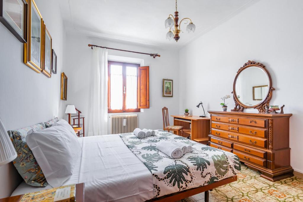 a bedroom with a bed and a dresser and a mirror at Pisa Airport Comfy Apartment - Private Parking in Pisa