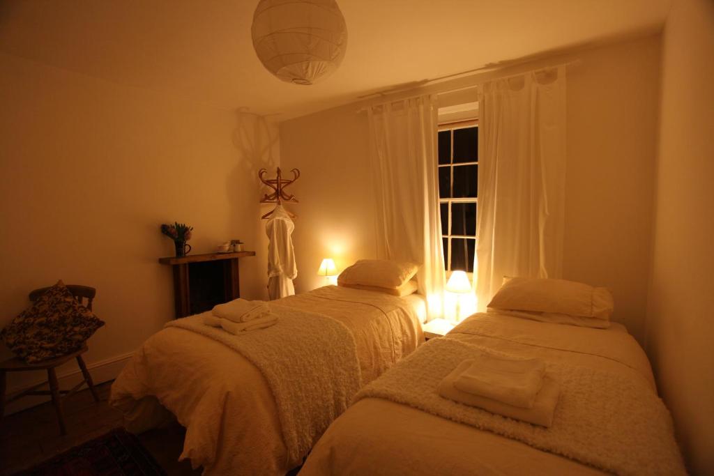two beds in a room with a window at Moon in the Apple Tree in Glastonbury