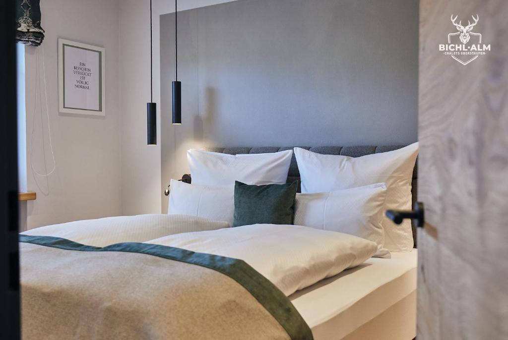 1 dormitorio con 1 cama con sábanas y almohadas blancas en Chalet Weidentraum, en Oberstaufen