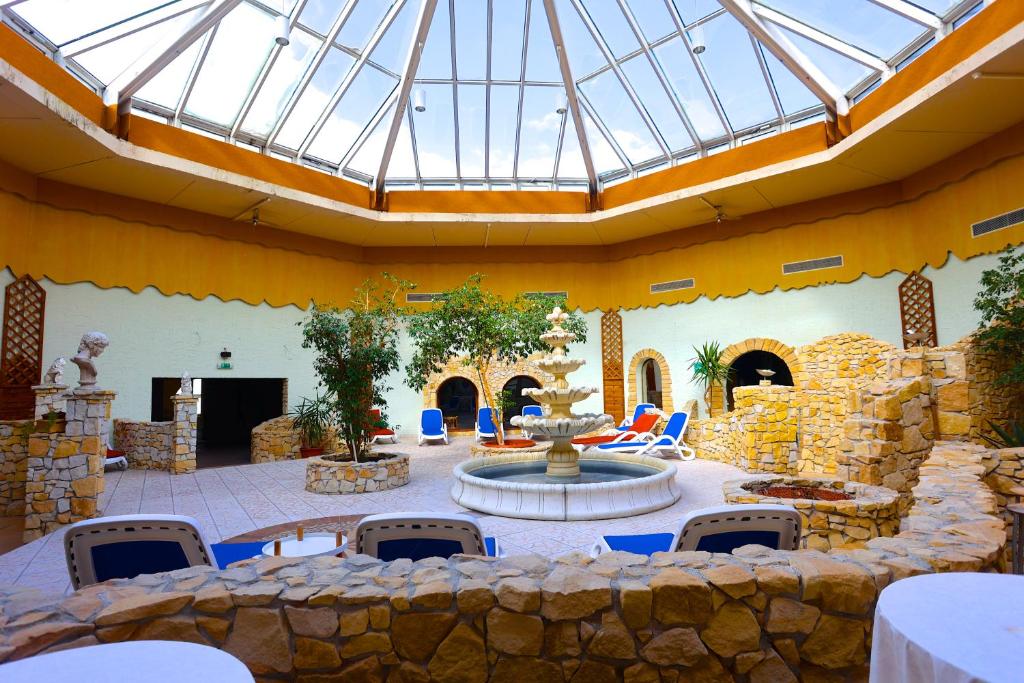 a patio with a fountain and a stone wall at Carea Harz Hotel Allrode in Allrode
