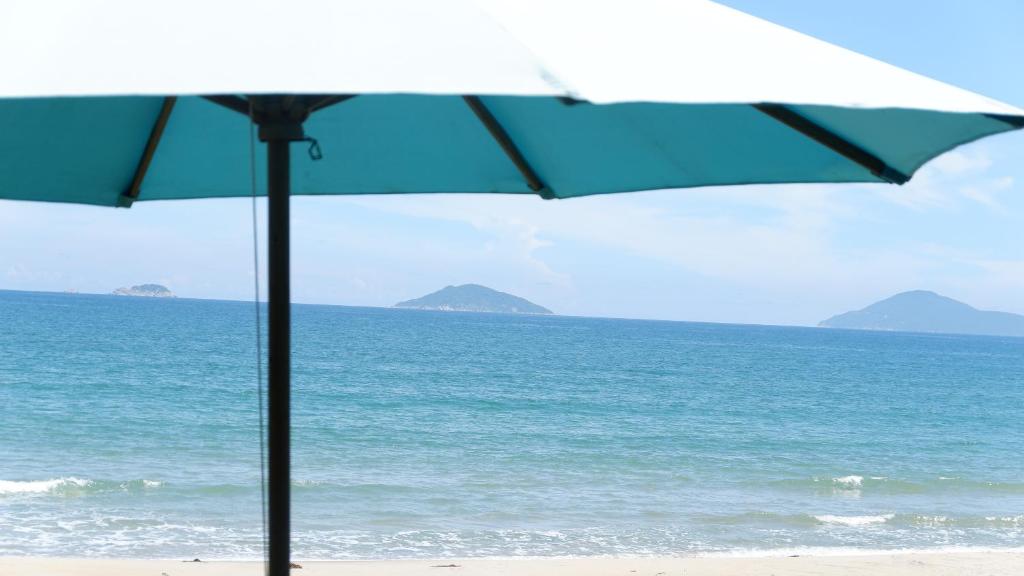 會安的住宿－隱逸海灘平房海景民宿，两把遮阳伞坐在海边