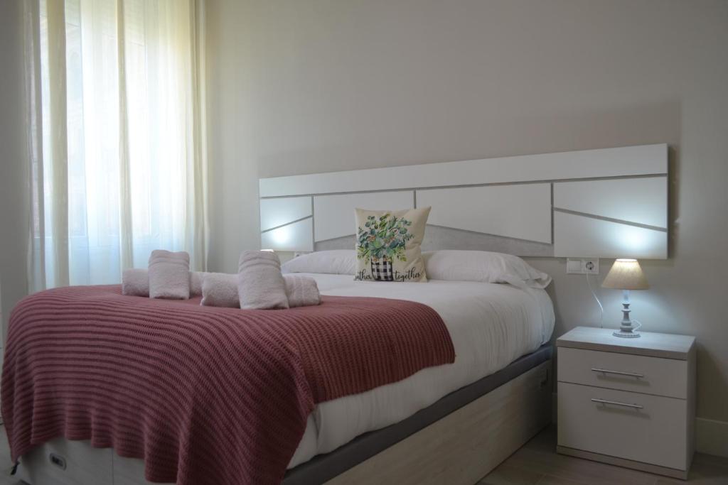 a bedroom with a large bed with a red blanket at SunShine Capricho de las Tendillas in Córdoba