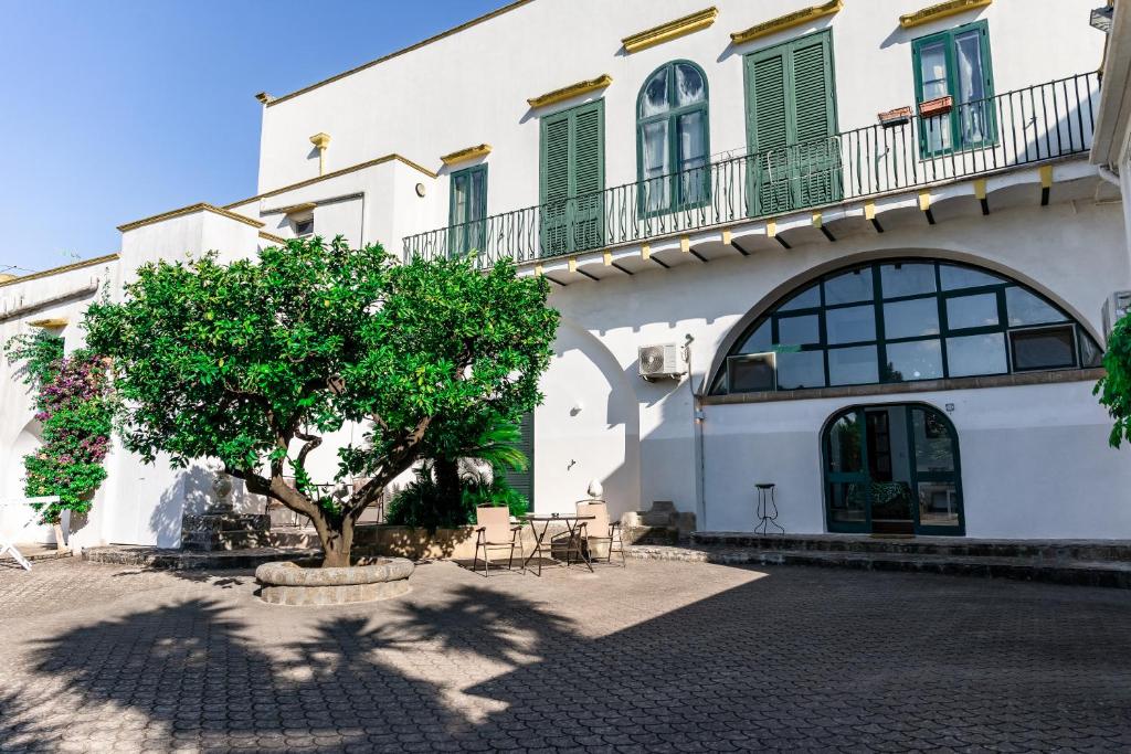 un edificio bianco con un albero di fronte di Casa Vacanza GICO' ad Alezio