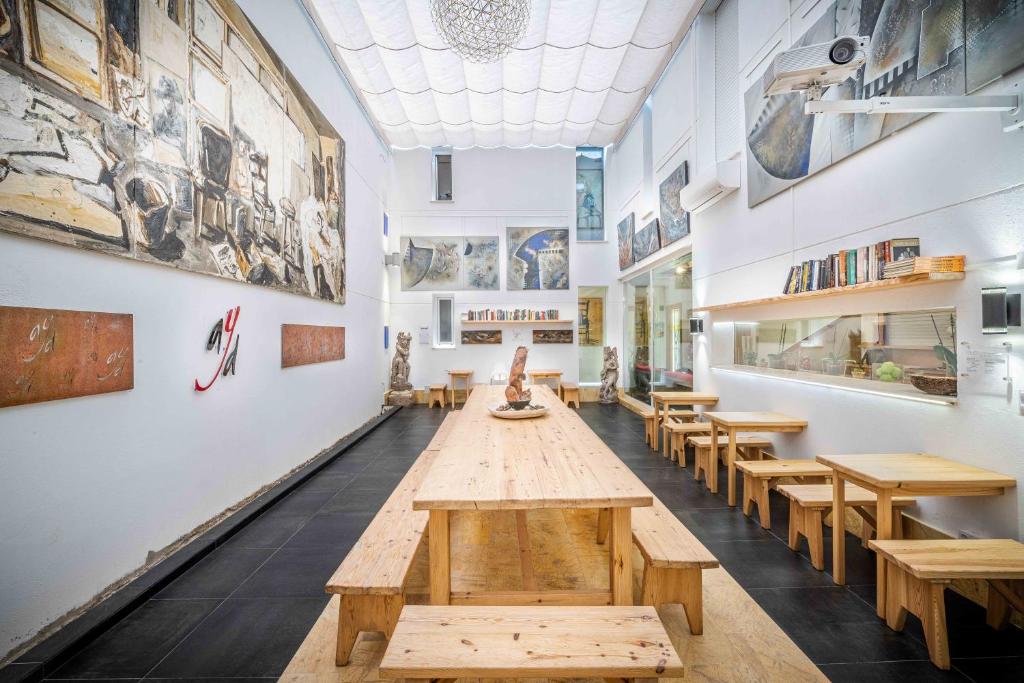 a large room with wooden tables and benches at Hotel Boutique Arte y Descanso in Almagro