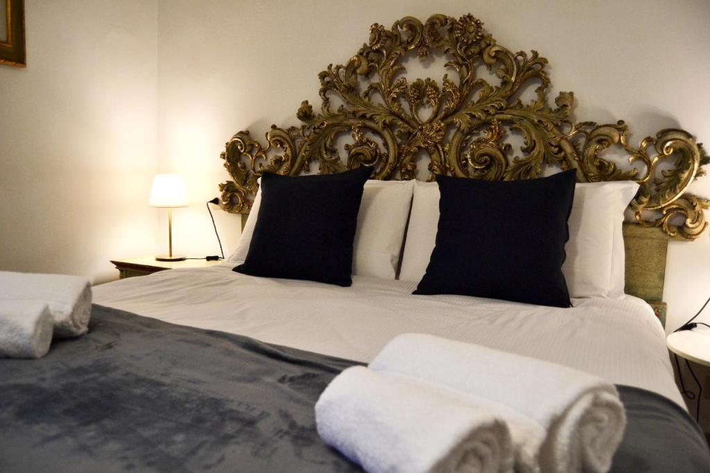 a bedroom with a large bed with a ornate headboard at Florence Heart B&B in Florence