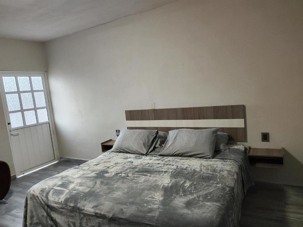 sypialnia z dużym łóżkiem z drewnianym zagłówkiem w obiekcie Suite privada w mieście San Martín de las Pirámides