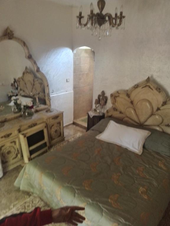 ein Schlafzimmer mit einem großen Bett und einem Spiegel in der Unterkunft Firma lfassiya in Dar SaÃ¯d Ben Hajj