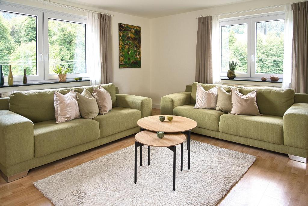 a living room with two couches and a table at Adesso - Ferienwohnung im Schwarzwald 