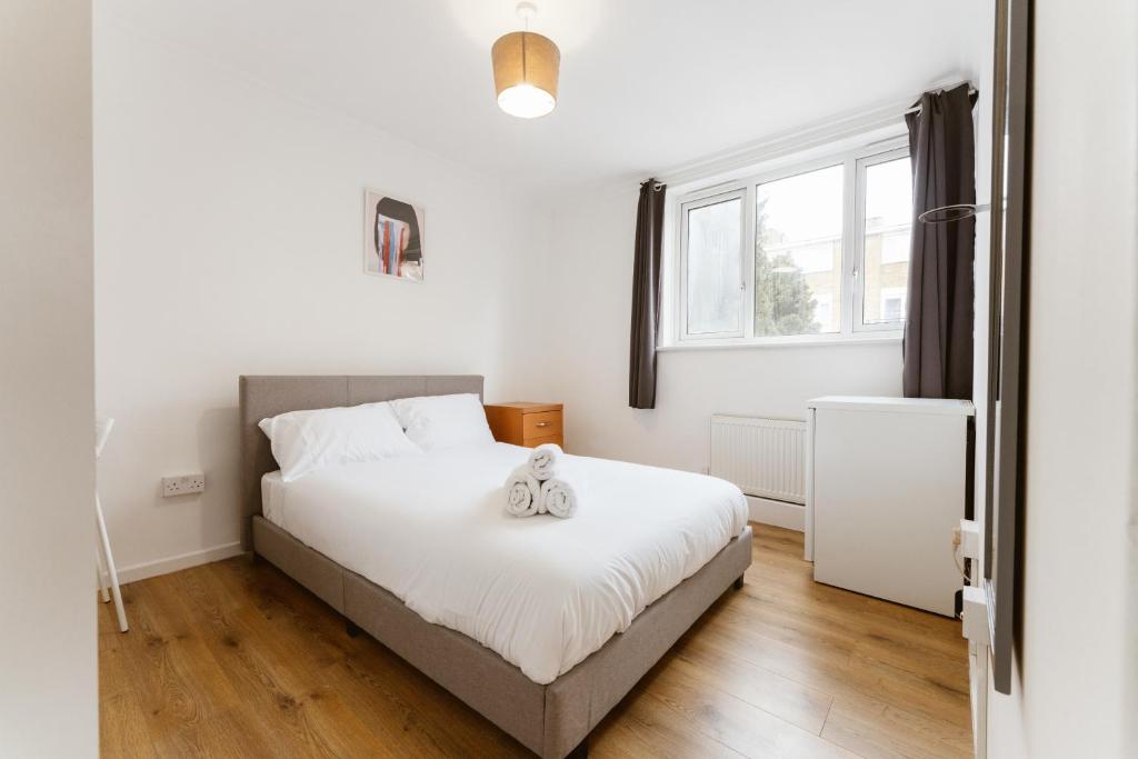 Schlafzimmer mit einem Bett und einem Fenster in der Unterkunft Wesferry beds to stay in London