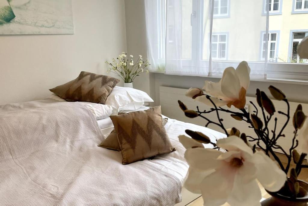 1 dormitorio con 2 camas con sábanas blancas y flores en Gemütliche Wohnung Nähe Rhein, en Basilea