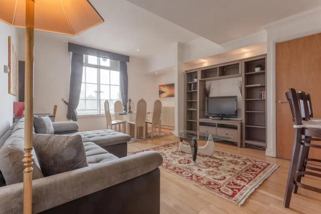 een woonkamer met een bank en een televisie bij Large & Central 2BD Flat - Tower Hill in Londen
