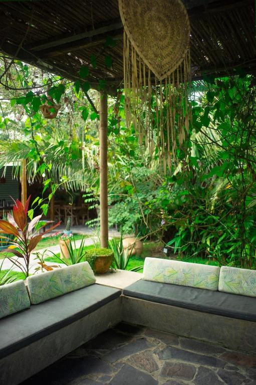 a patio with two benches in a garden at Ekaa Hotel in Palomino