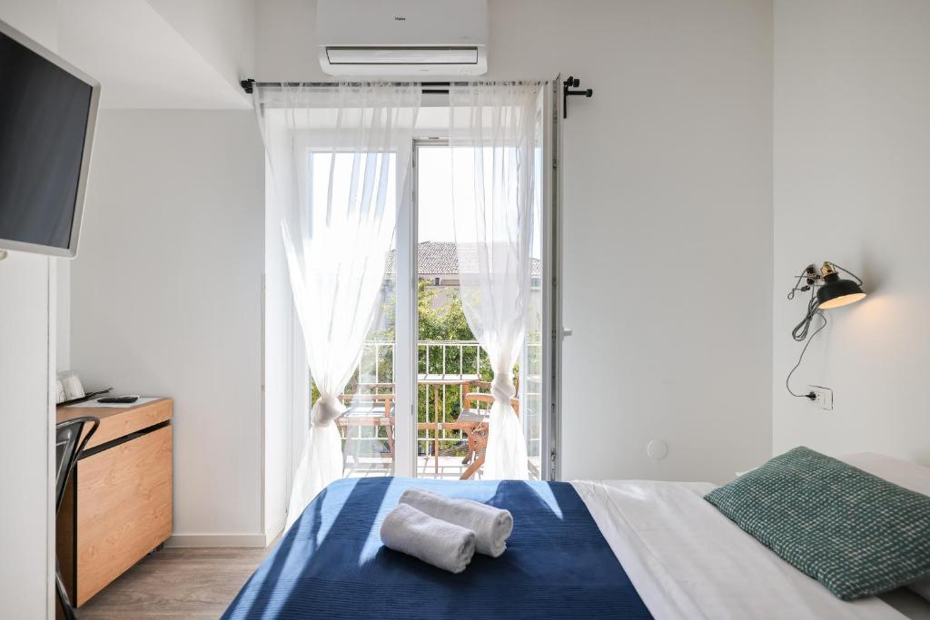 a bedroom with a bed and a large window at Zaratino rooms in Zadar