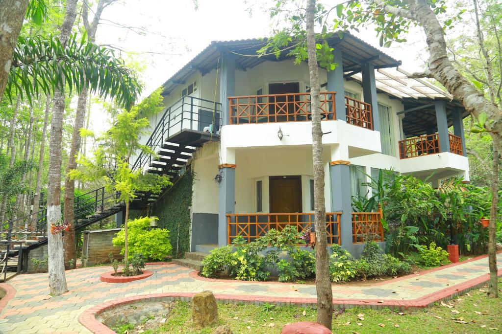a house in the middle of a garden at Kolaahalam Mainland Resorts & Spa in Yercaud