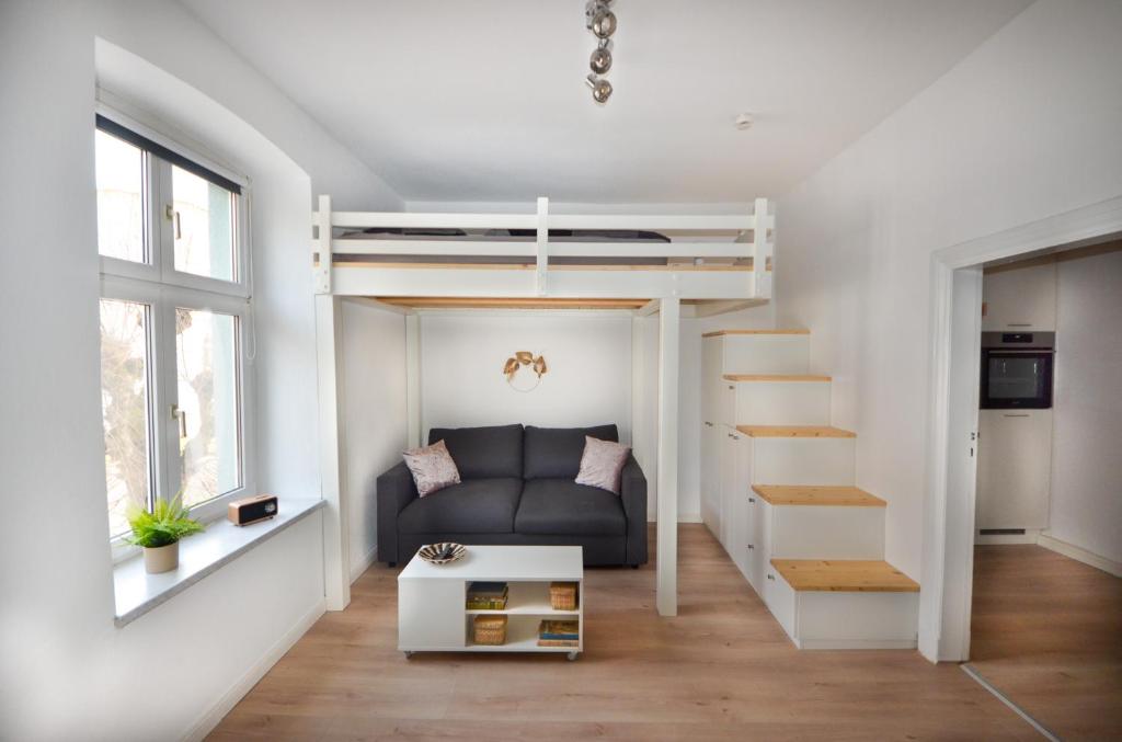 een woonkamer met een hoogslaper en een bank bij Apartmenthaus Fritz Reuter in Schwerin