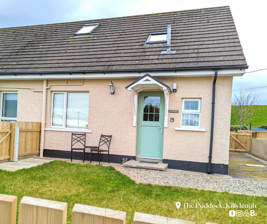 a house with a blue door and a fence at The Paddock in Killyleagh