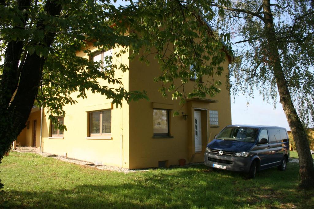 a van parked in front of a yellow house at Ferienhaus im Grünen in Morbach