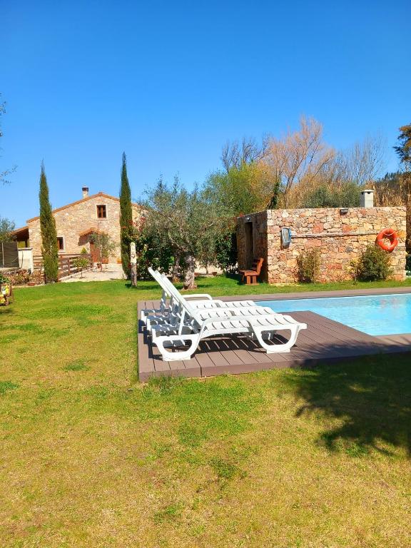 a group of white benches sitting next to a pool at Carregã Water mill in Penela