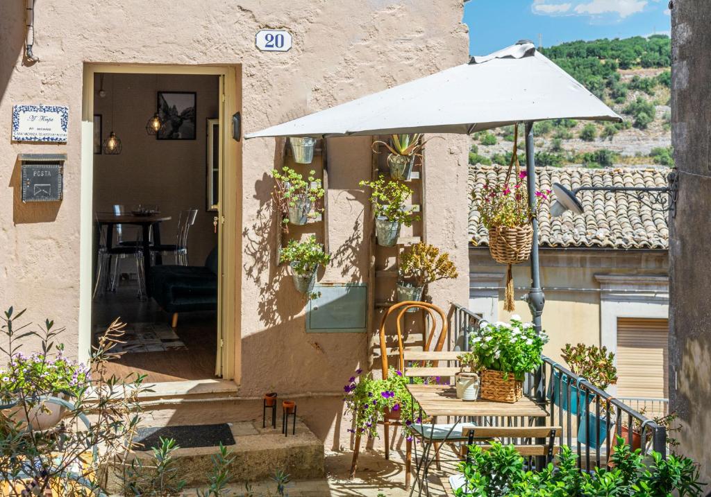 patio con tavolo e ombrellone di A Timpa ro Nannu 20, Holiday Home in Center Ragusa IBLA a Ragusa