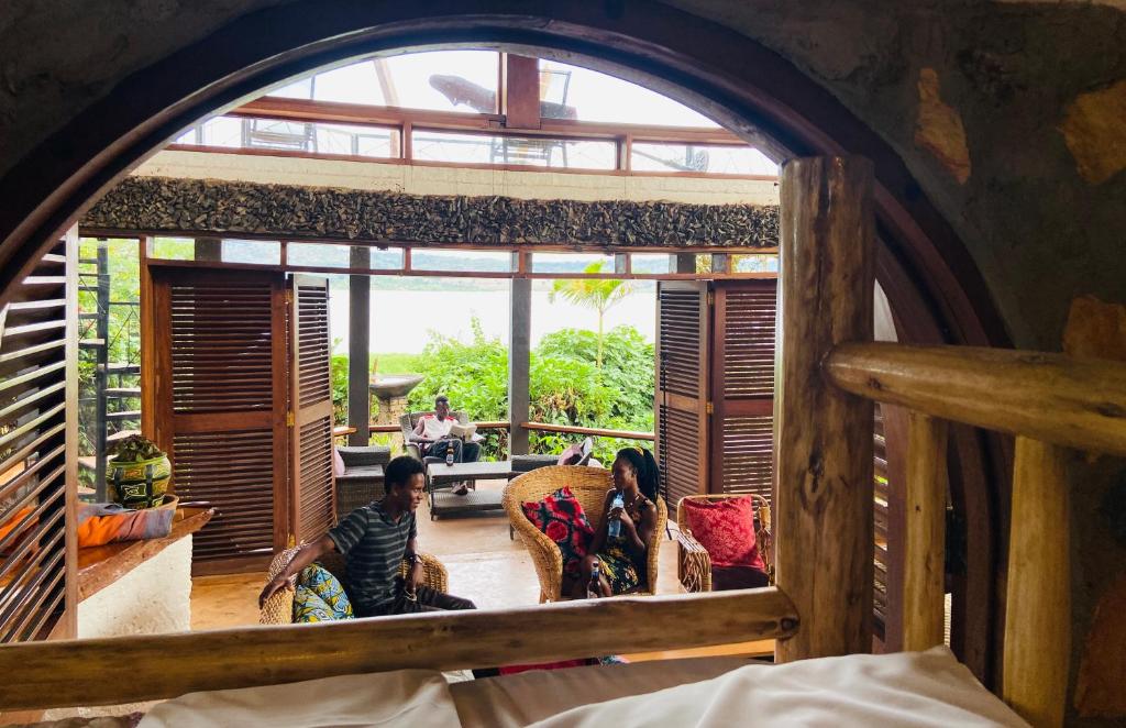 eine Gruppe von Menschen, die in einem Raum auf Stühlen sitzen in der Unterkunft Home OnThe Nile Dorm in Jinja