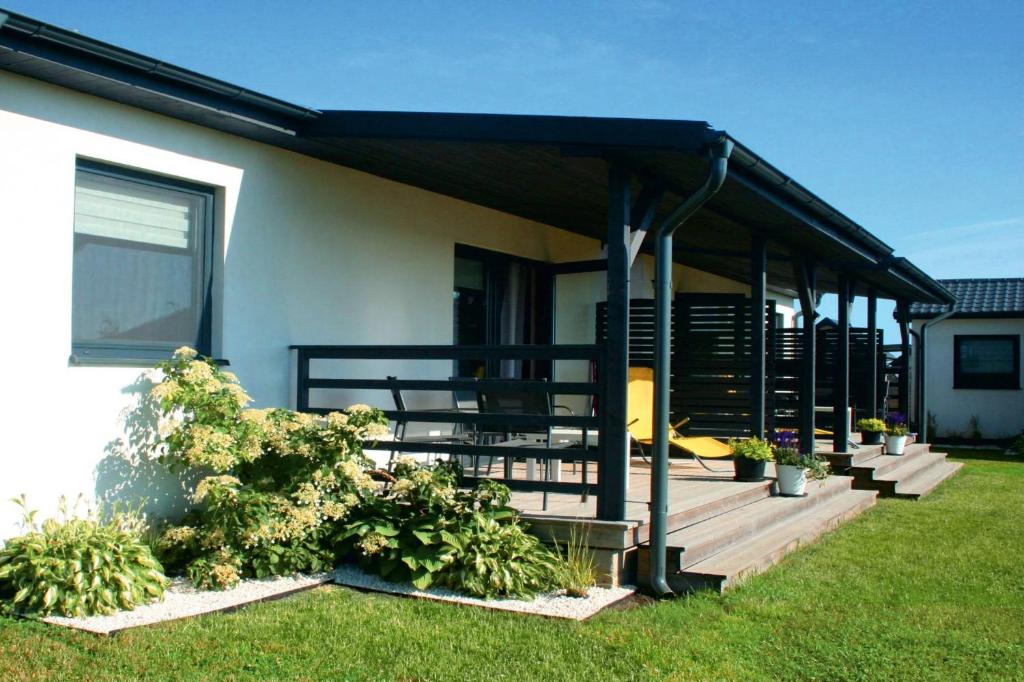 ein Haus mit einer Terrasse mit blauer Markise in der Unterkunft Domki Selma in Władysławowo