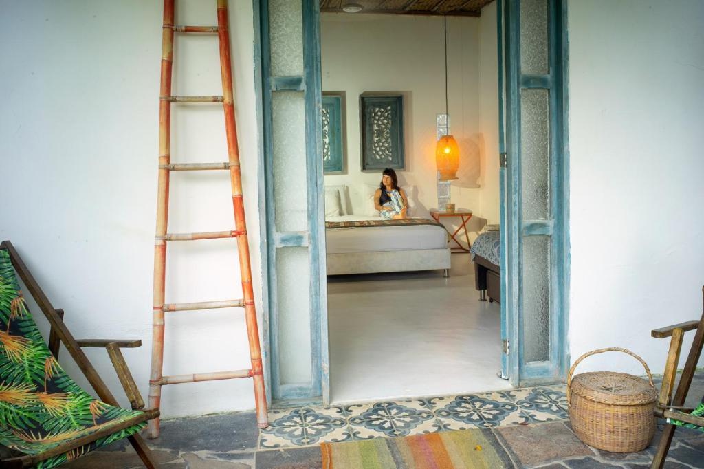 a woman is standing in a room with a bathroom at Ekaa Hotel in Palomino