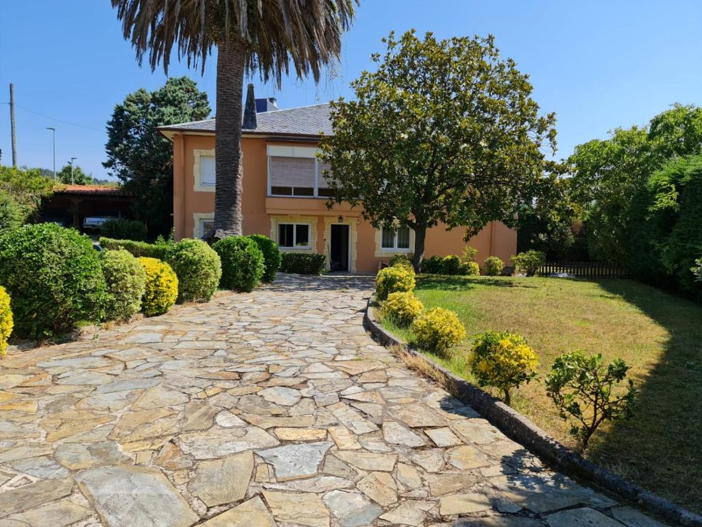 a stone walkway in front of a house at Villa La Palmera in Mortera