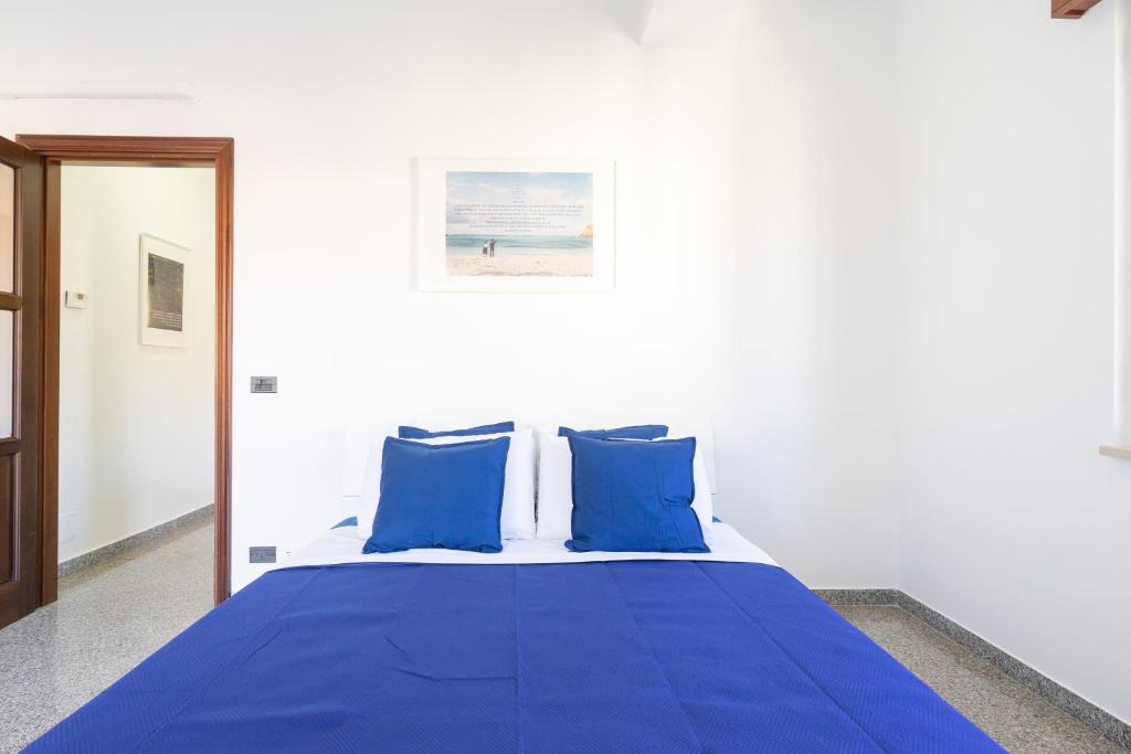 1 dormitorio con cama azul y almohadas azules en Casa Ludo, en Soverato Marina