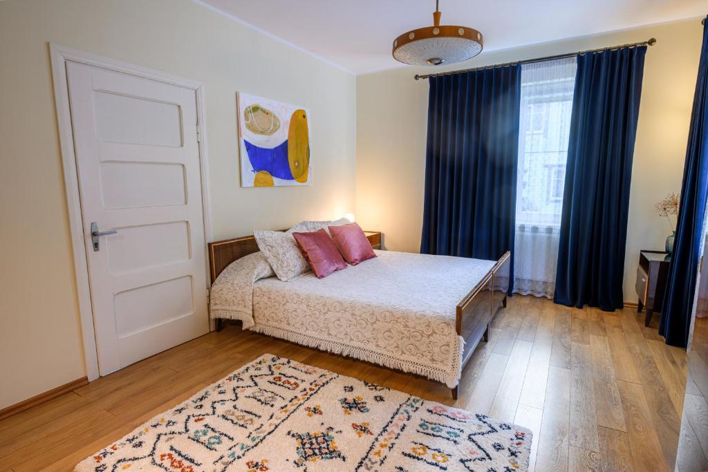 1 dormitorio con cama, puerta y alfombra en Zofija, en Birštonas