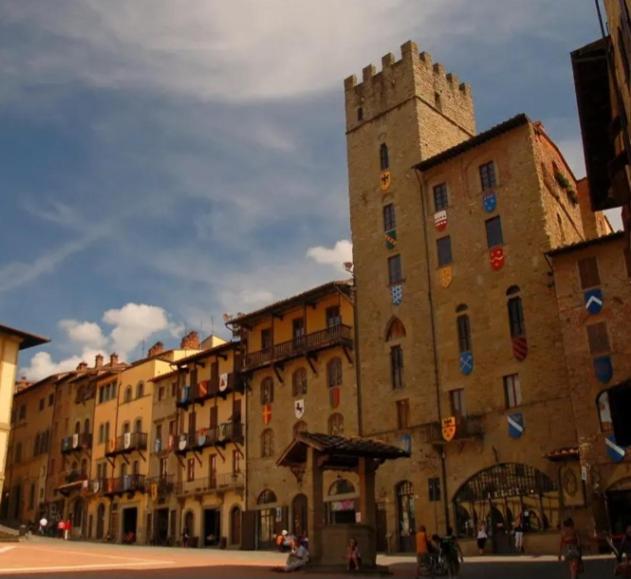 a large building with a tower on a city street at piccolo Garibaldi appartamento in Arezzo