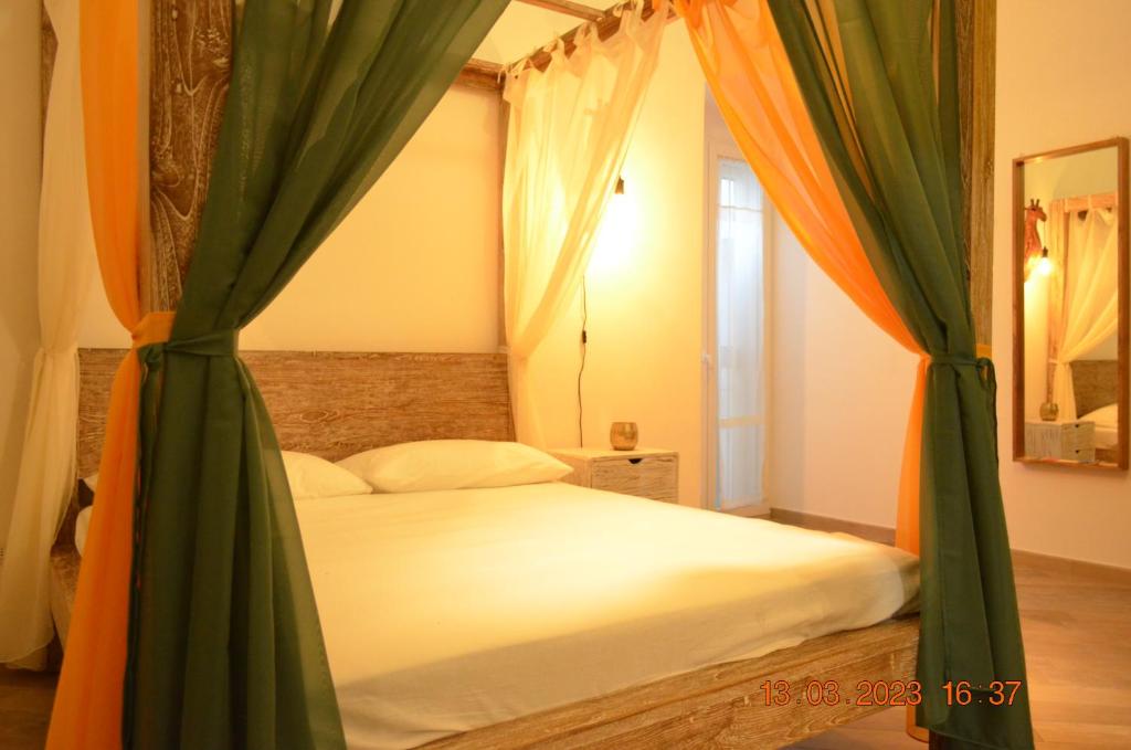 Schlafzimmer mit einem Bett mit grünen und orangen Vorhängen in der Unterkunft La Casetta di Zoe Apartment in Molfetta