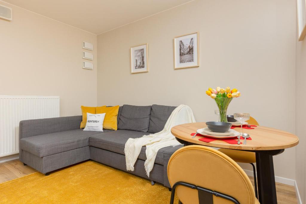 a living room with a couch and a table at Pet-Friendly Studio Kokoryczki by Renters in Warsaw