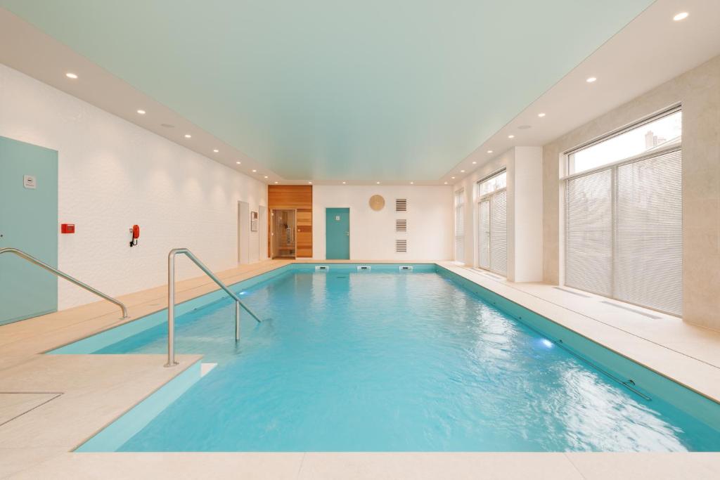 una piscina de agua azul en un edificio en Domitys La Cristal'In en Nancy