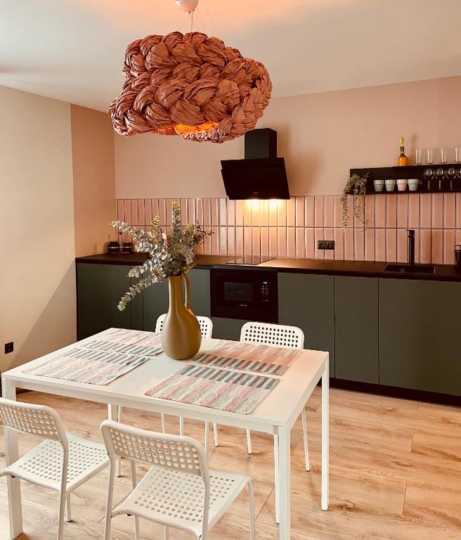 a white table with chairs and a vase on it in a kitchen at M a t c h a in Ventspils