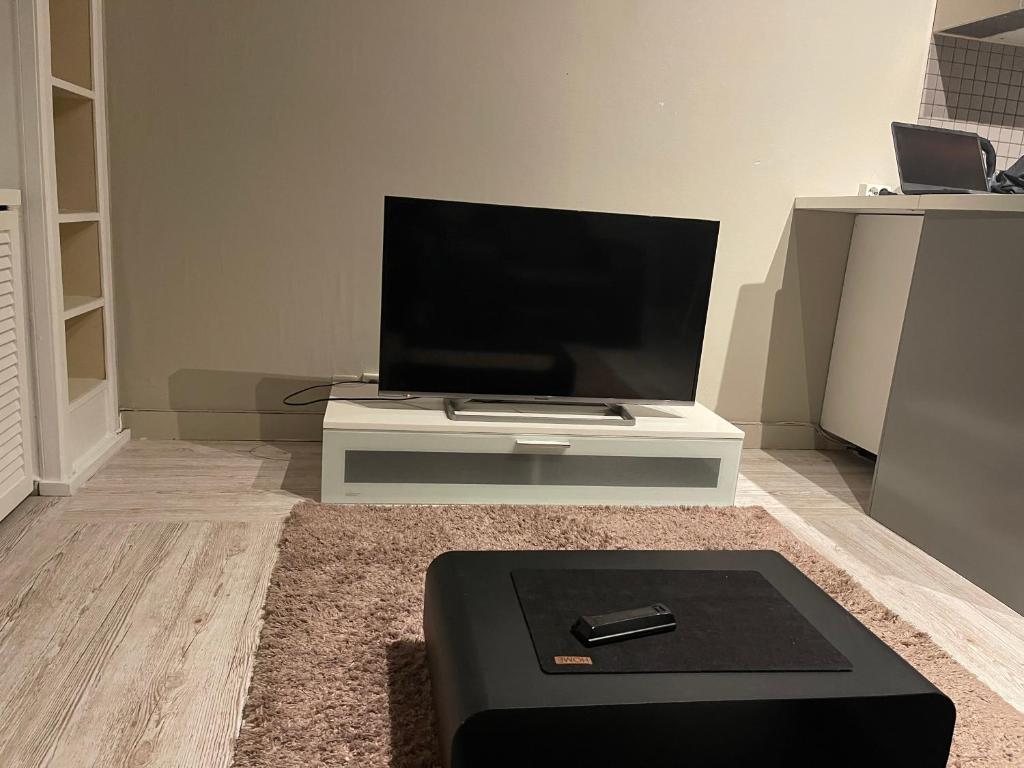 sala de estar con TV de pantalla plana sobre una mesa en Oslo Center, en Oslo