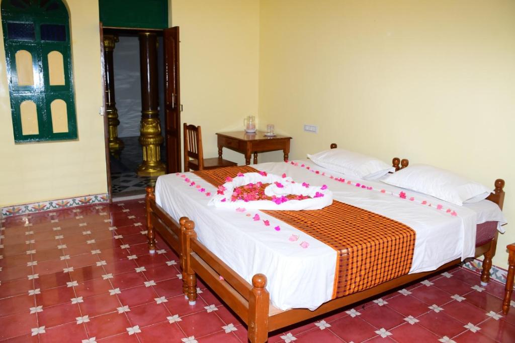 Postel nebo postele na pokoji v ubytování chettinad Manor