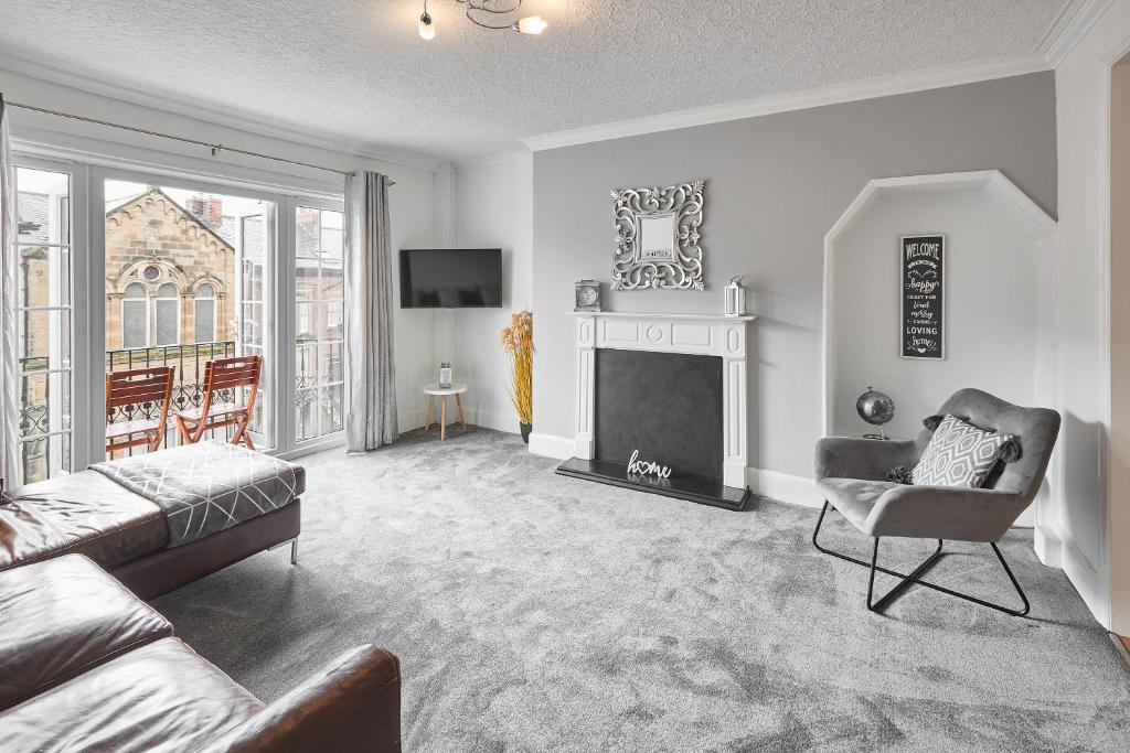 a living room with a couch and a fireplace at Glencoe Holiday Apartments Whitby in Whitby