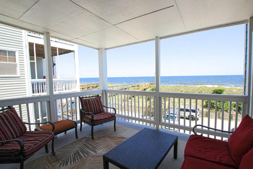 a screened in porch with a view of the ocean at Souls in the Sand in Carolina Beach