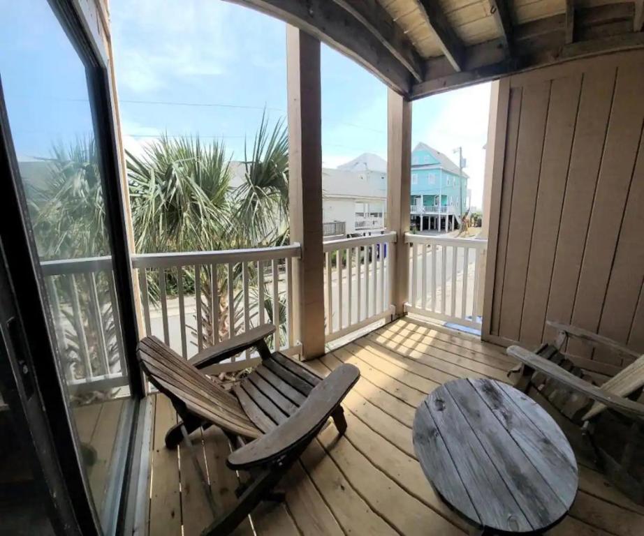 a porch with a table and chairs on a balcony at The Narrow Nest in Carolina Beach