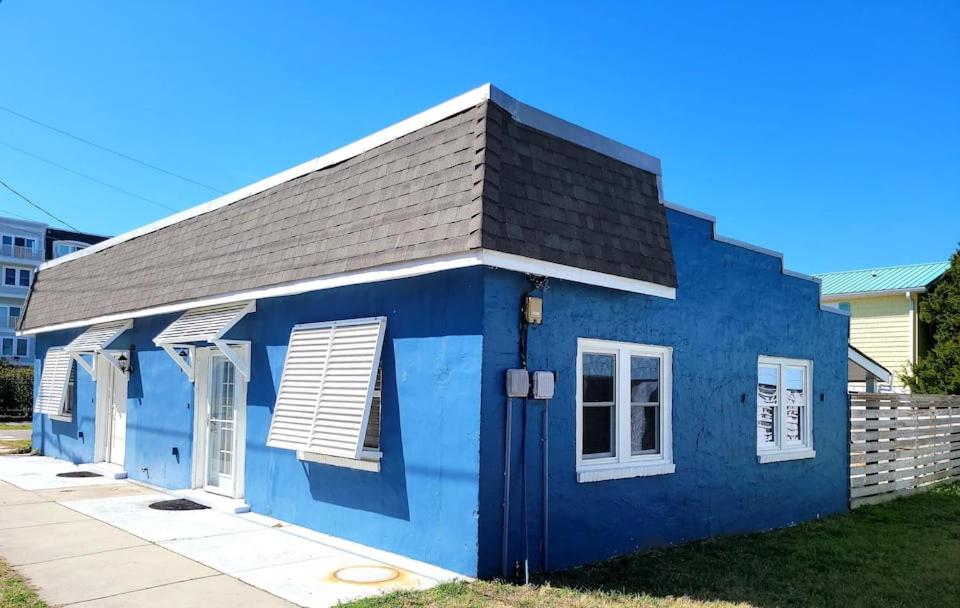 una pequeña casa azul con techo negro en Beachwood Bungalow A en Carolina Beach