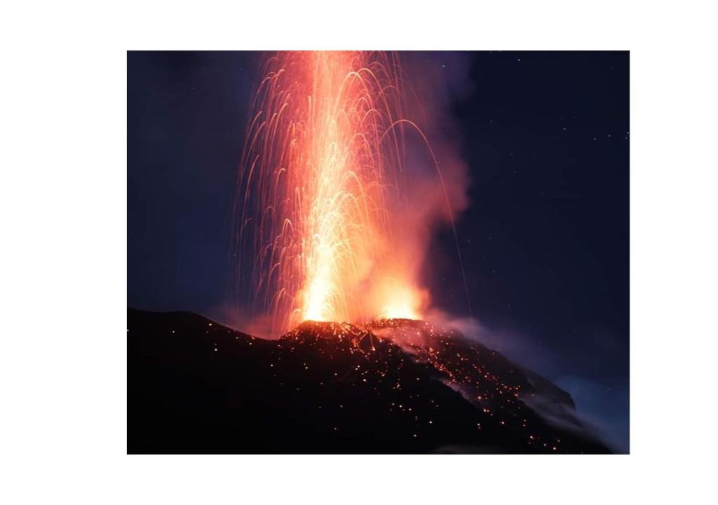 a lava eruption in the sky at night at Stromboli Central Family Apartment - 3 Double Rooms in Stromboli