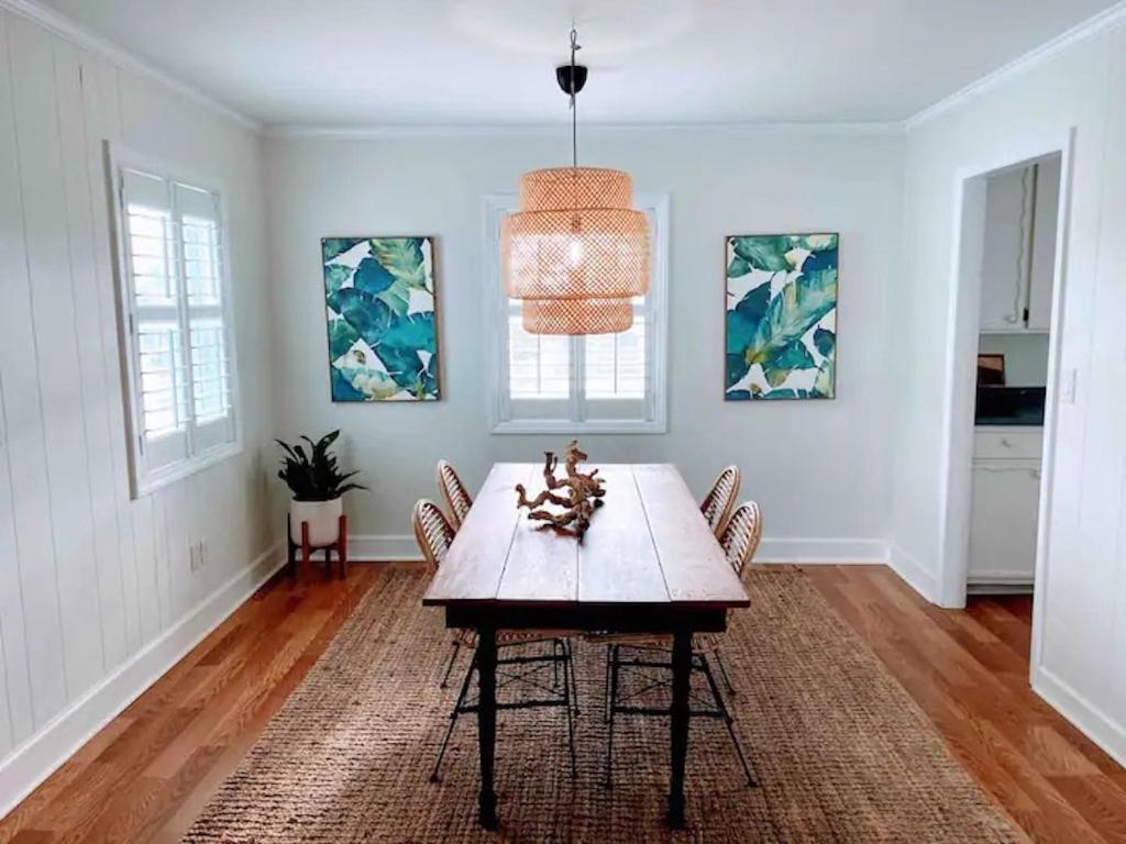 una sala da pranzo con tavolo e sedie in legno di Vitamin Sea a Carolina Beach