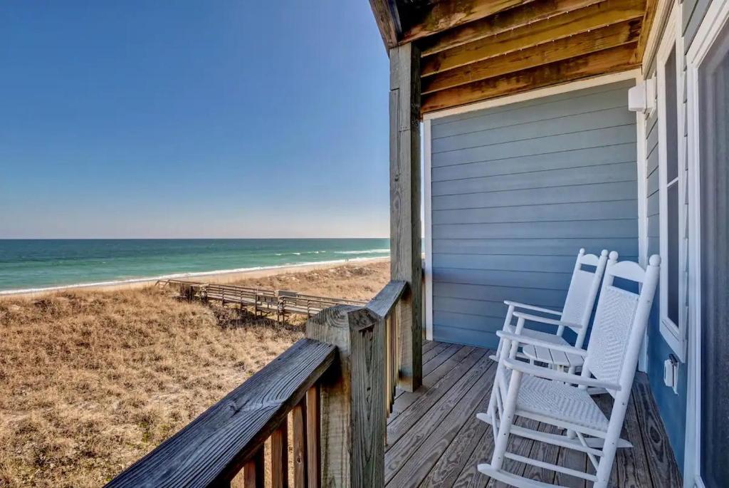 2 sillas en el porche de una casa de playa en Island Treasure, en Carolina Beach