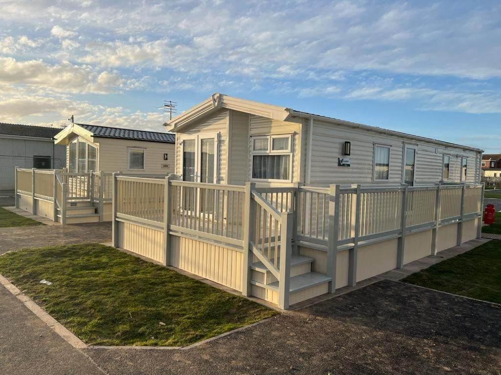 a mobile home with a deck and a fence at 8 Berth 3 Bed PG213 on the Golden Palm in Chapel Saint Leonards