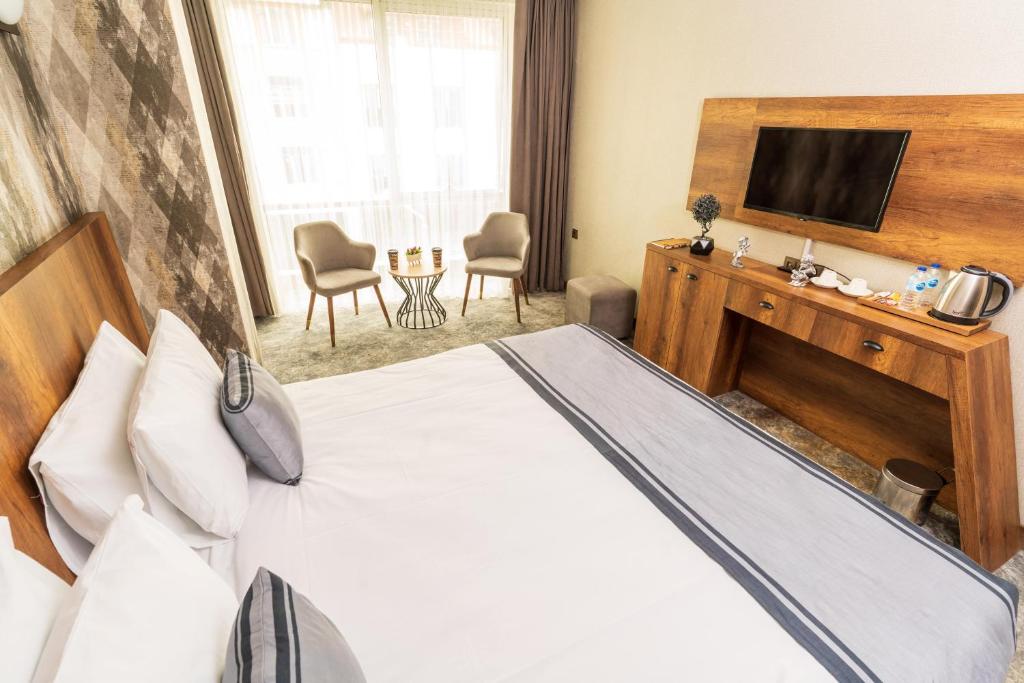 um quarto de hotel com uma cama e uma televisão em Istanbul Airport Express Hotel em Arnavutköy