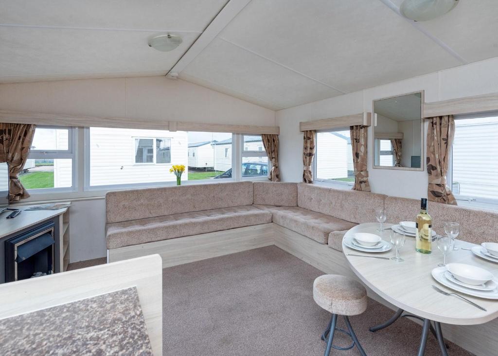 een woonkamer met een bank en een tafel bij Stunning Home In Prestatyn, Denbighshire W- in Prestatyn
