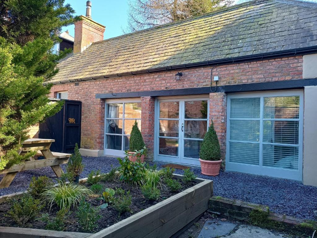 a brick house with a garden in front of it at The West Wing at Eriviat Hall Hot Tub in Henllan