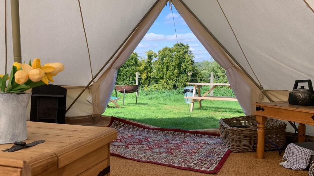 a canvas tent with a view of a yard at Home Farm Radnage Glamping Bell Tent 2, with Log Burner and Fire Pit in Radnage