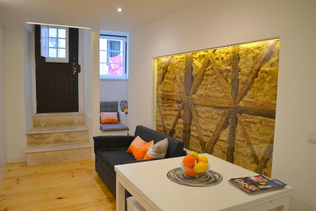 ein Wohnzimmer mit einem Sofa und einem Gemälde an der Wand in der Unterkunft TP BICA 20, Lisbon Apartment in Lissabon